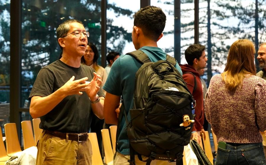 Attendee gesturing mid-conversation with a student during speed teaming