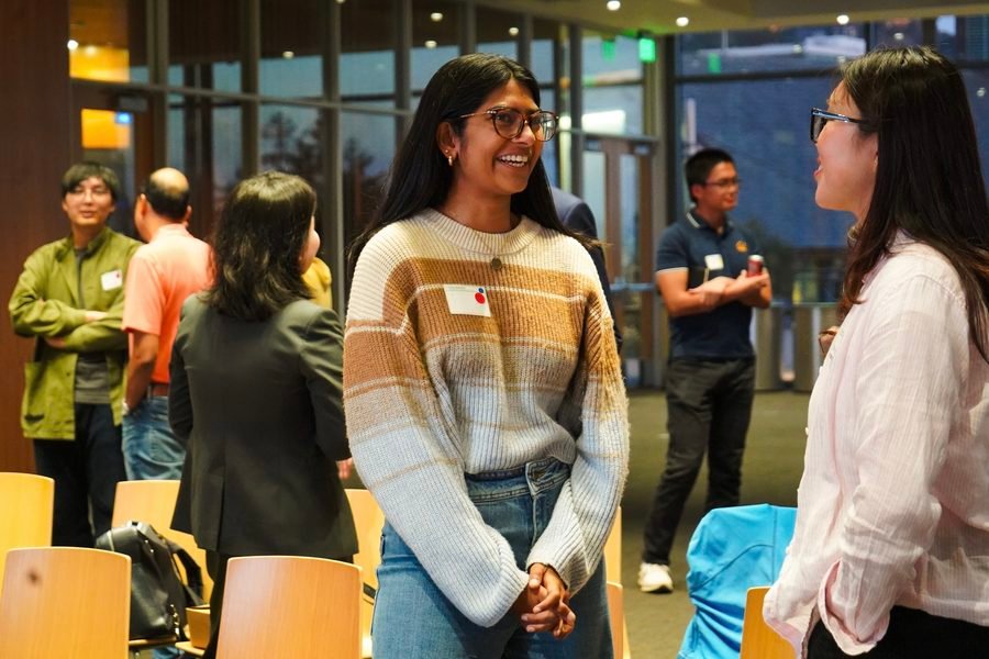 Two attendees smiling in conversation during speed teaming