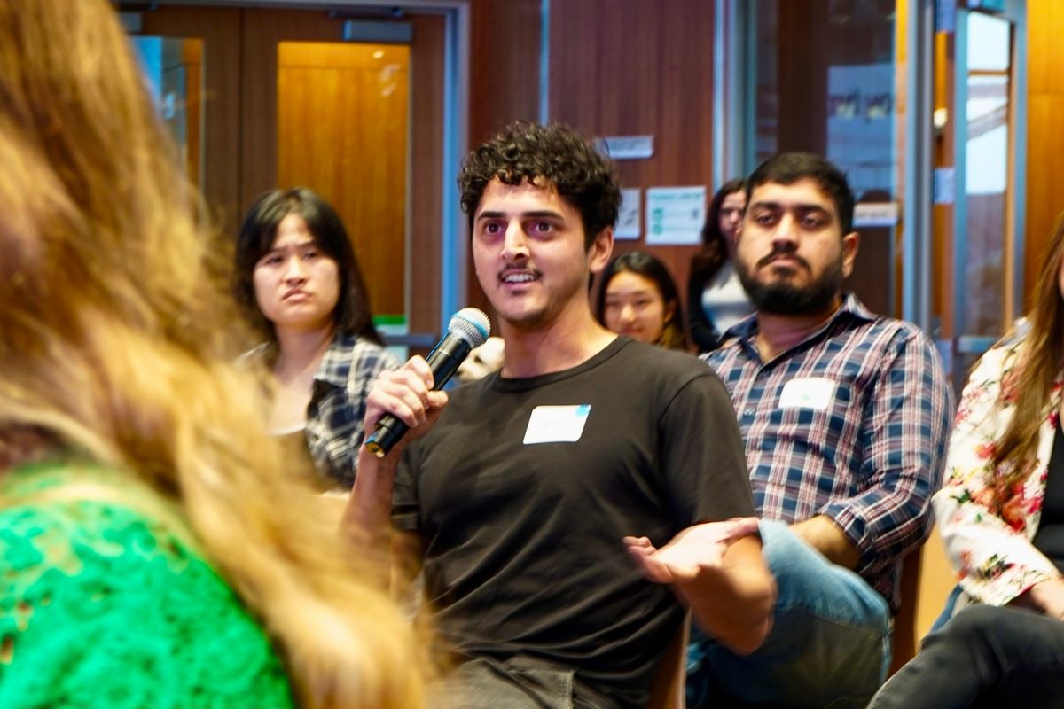 An attendee asking a question into a microphone during the Q&A
